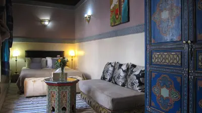 a bedroom with a bed and a couch and a table at Riad Maizie in Marrakech