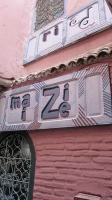 a sign on the side of a pink building at Riad Maizie in Marrakech