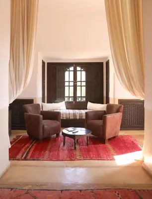 a living room with two chairs and a coffee table at Villa Le Perroquet Bleu in Marrakech
