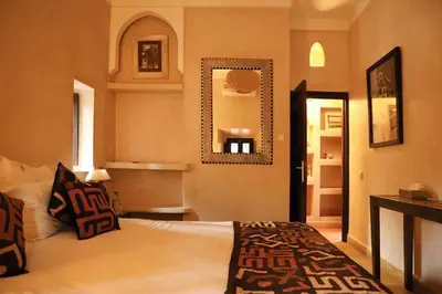 a bedroom with a bed and a mirror on the wall at Villa Le Perroquet Bleu in Marrakech