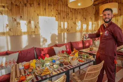 a man standing in front of a table of food at Riad Tassili Boutique in Marrakech