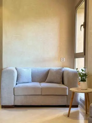 a living room with a couch and a table at Exceptional Golf View Apartment, Prestigia in Marrakech