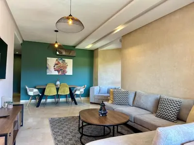 a living room with a couch and a table at Exceptional Golf View Apartment, Prestigia in Marrakech