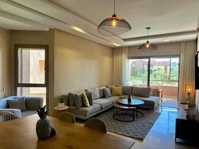 a living room with a couch and a table at Exceptional Golf View Apartment, Prestigia in Marrakech