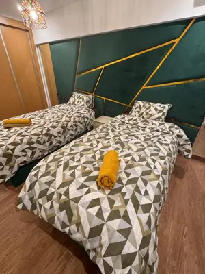 a bedroom with two beds with a yellow pillow on it at Appartement Naïel Palmeraie avec piscine in Marrakech