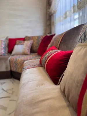 a couch with pillows on it in a living room at Appartement Naïel Palmeraie avec piscine in Marrakech