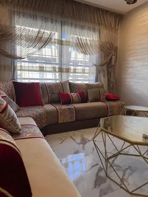 a living room with a couch and a window at Appartement Naïel Palmeraie avec piscine in Marrakech