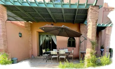 a patio with a table and an umbrella at Appartement à Marrakech in Marrakech