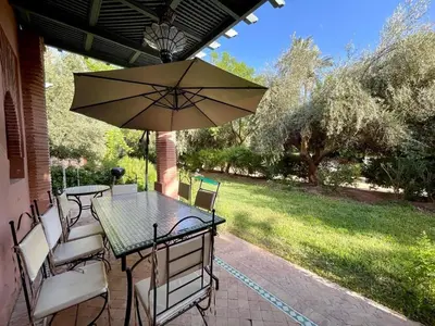 a table and chairs with an umbrella on a patio at Appartement à Marrakech in Marrakech