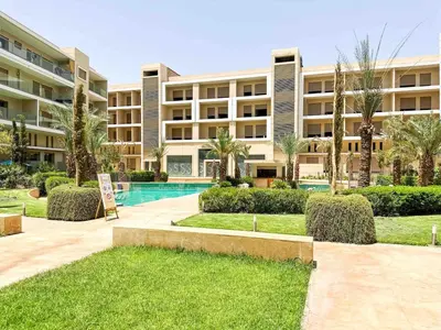 a large apartment building with a swimming pool at Perl garden in Marrakech