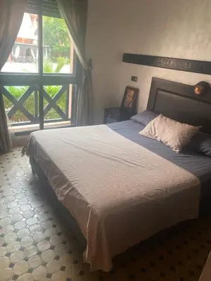 a bedroom with a large bed with a large window at beautiful appartment Premium village in Marrakech