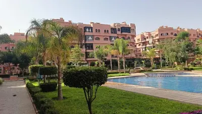 a large apartment complex with a swimming pool and palm trees at beautiful appartment Premium village in Marrakech