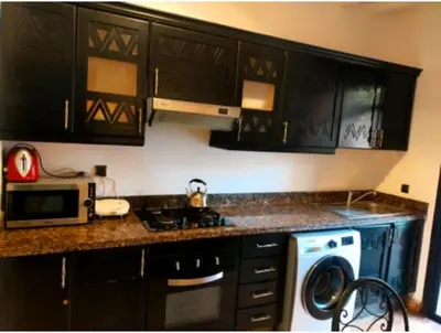 a kitchen with black cabinets and a washer at beautiful appartment Premium village in Marrakech