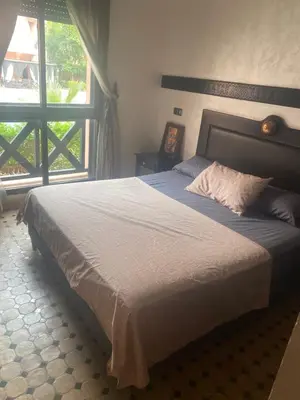 a bedroom with a large bed with a large window at beautiful appartment Premium village in Marrakech