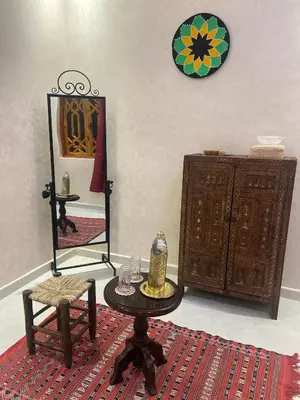 a room with a table and a mirror and a chair at Riad dar lakbira in Marrakech