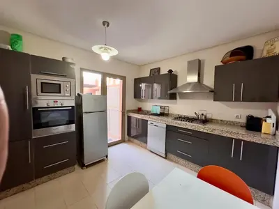a kitchen with black cabinets and stainless steel appliances at فيلا فاخرة في مراكش مع حديقة خاصة ومسبح - تجربة استرخاء لا تُنسى in Marrakech