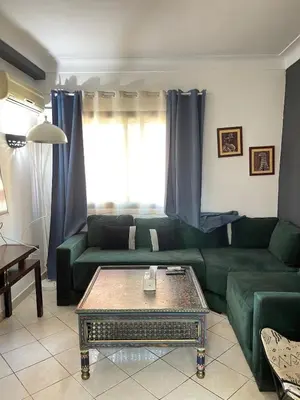 a living room with a green couch and a coffee table at Comfortable apartment in the center of Gueliz in Marrakech