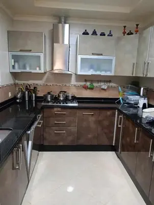 a kitchen with wooden cabinets and stainless steel appliances at appartement meuble in Marrakech