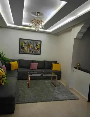 a living room with a couch and a chandelier at appartement meuble in Marrakech