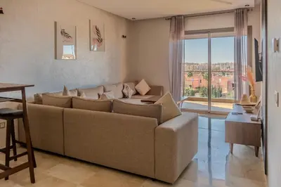 a living room with a couch and a large window at City Haven at Pearl Garden Pool and View in Marrakech