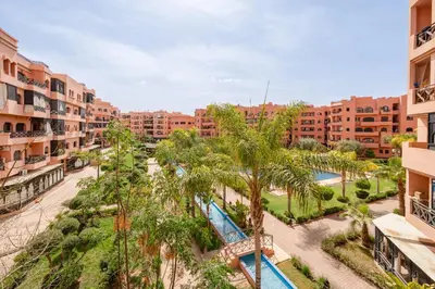 an aerial view of a resort with a pool and palm trees at Luxury Residence with 2 Terraces Pool and Garden View Security and Self Check-in in Marrakech
