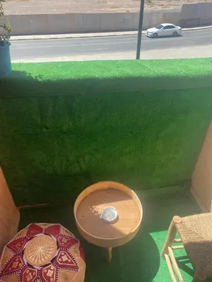 a green wall with a table and a stool at Modern central apartment 2 bedrooms in Marrakech