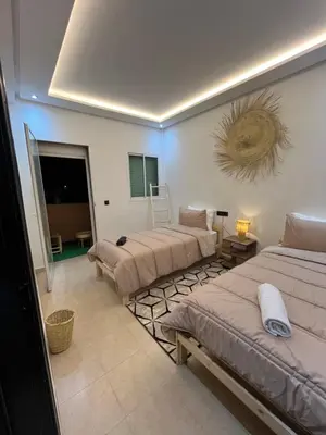 a room with three beds and a television in it at Modern central apartment 2 bedrooms in Marrakech