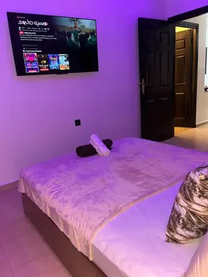 a purple room with a bed with a tv on the wall at Modern central apartment 2 bedrooms in Marrakech