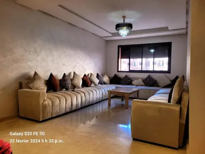 a living room with a large couch and a table at Sublime appartement au coeur de Marrakech in Marrakech