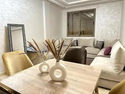 a living room with a table with two vases on it at New and modern apartment in Marrakech