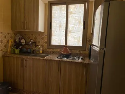 a kitchen with a sink and a refrigerator and a window at Location appartement a Marrakech aboib gulez in Marrakech