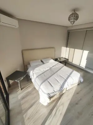 a bedroom with a large bed and a table at Appartement calme, proche de toutes commodités in Marrakech