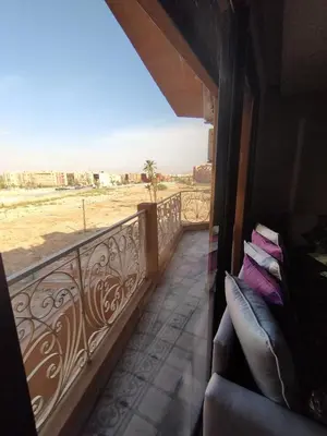 a balcony with a couch and a view of the desert at Appartement calme, proche de toutes commodités in Marrakech