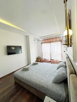 a bedroom with a large bed and a flat screen tv at Luxe Studio Gueliz in Marrakech