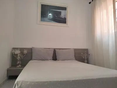 a bed in a bedroom with a picture on the wall at LOGEMENT ENTIER MARRAKECh G26 N 35 in Marrakech