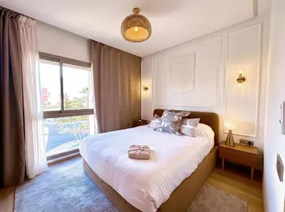 a bedroom with a large bed and a large window at Prestigia Saphir Luxury 3 Bedrooms, Pool & Golf View, near Airport in Marrakech