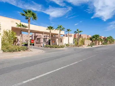 an empty street with palm trees and a building at Prestigia Saphir Luxury 3 Bedrooms, Pool & Golf View, near Airport in Marrakech
