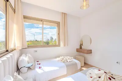 a white room with two beds and a window at Appât hôtel in Marrakech