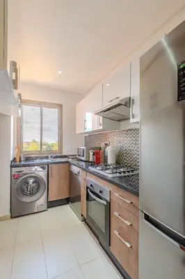 a large kitchen with a washer and dryer in it at Appât hôtel in Marrakech