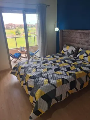 a bedroom with a bed with a colorful quilt at prestigia agate apt haut standing meublé in Marrakech