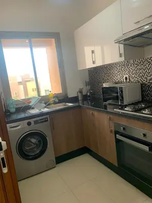 a kitchen with a washing machine and a microwave at prestigia agate apt haut standing meublé in Marrakech