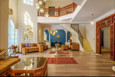 a living room filled with furniture and a staircase at Palais Rhize targa in Marrakech