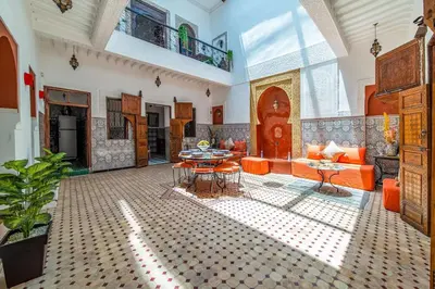 a living room with orange furniture and a table at Riad Khadoj-Marrakech-Traditional in Marrakech