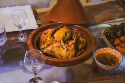 a bowl of food on a table with wine glasses at Riad Yuna in Marrakech