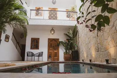 a house with a swimming pool in front of a building at Riad Yuna in Marrakech
