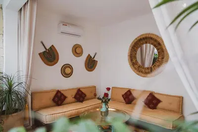 a living room with a couch and a mirror at Riad Yuna in Marrakech
