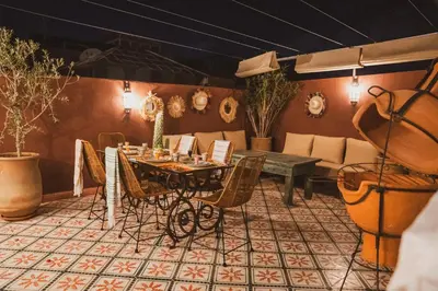 a dining room with a table and chairs and a couch at Riad Yuna in Marrakech