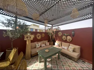 a patio with a couch and a table and chairs at Riad Yuna in Marrakech
