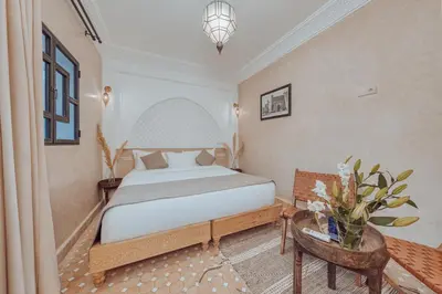 a bedroom with a bed and a table at Riad Valentine in Marrakech