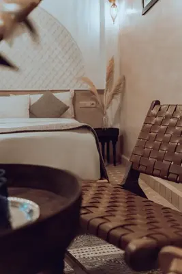a bedroom with a bed and a chair and a table at Riad Valentine in Marrakech